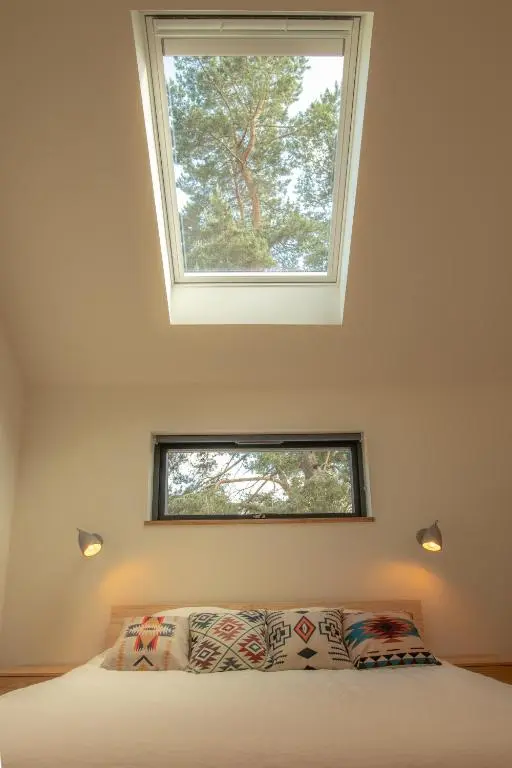 a room with a bed with a skylight above it at Arbor Nethy Bothy in Cairngorms National Park in Nethy Bridge