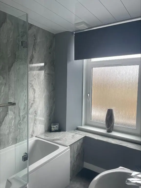 a bathroom with a bath tub and a window at The Brig & Barrel hotel in Buckie