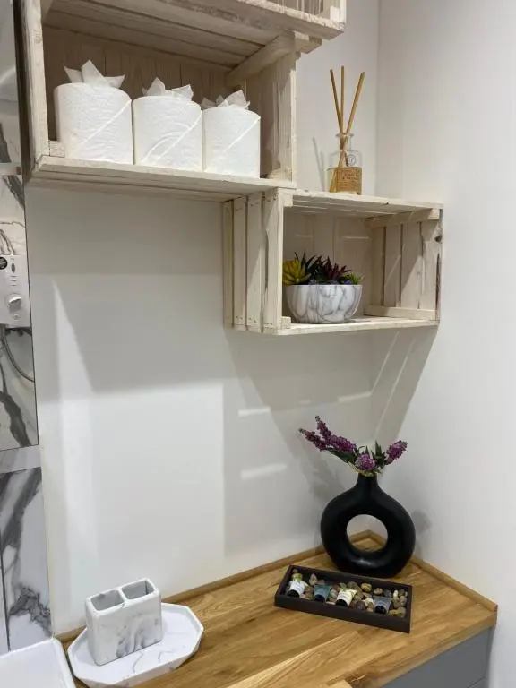 a bathroom with a shelf with toiletries on a table at 51 Innes Street Apartment in Inverness