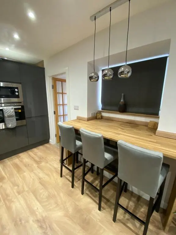 a kitchen with a wooden table and chairs at 51 Innes Street Apartment in Inverness