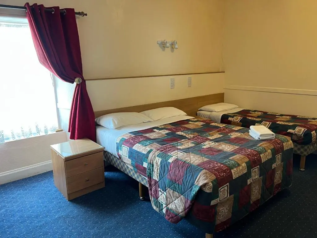 a hotel room with two beds and a window at Strathpeffer Hotel in Strathpeffer