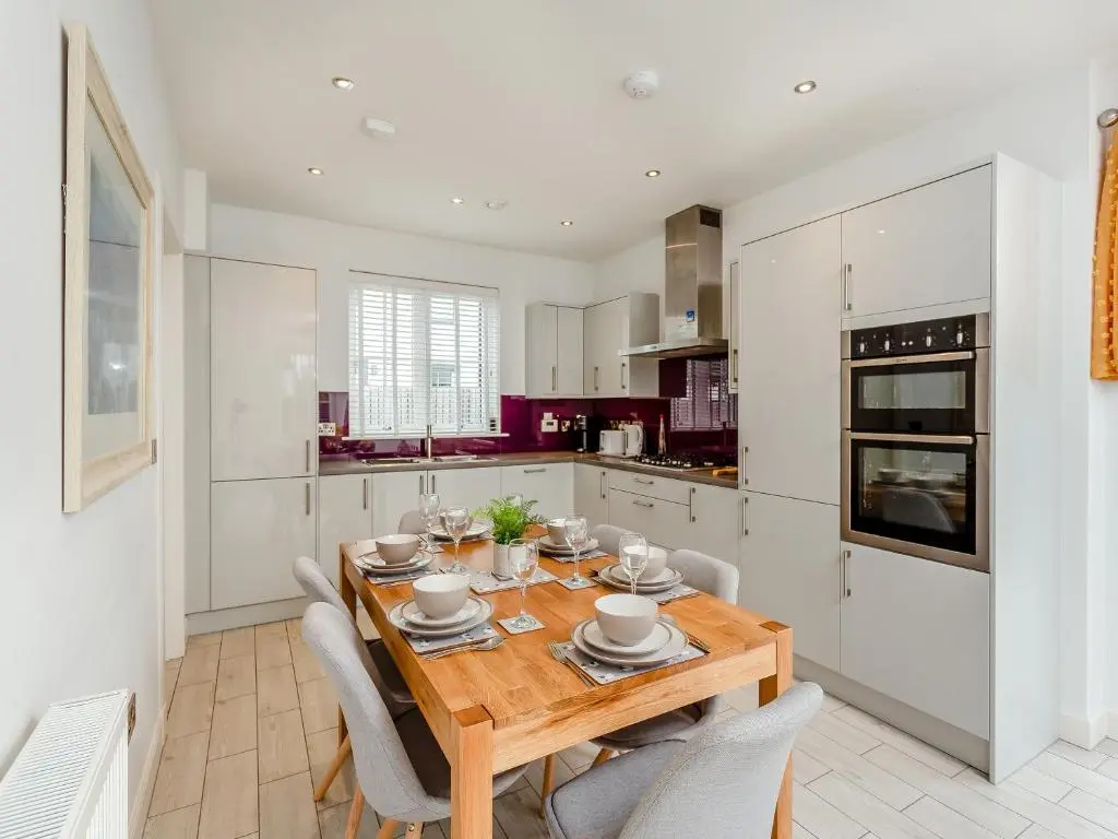 a kitchen and dining room with a wooden table and chairs at One The Loan in Croy