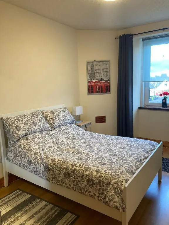 a bedroom with a bed and a window at 2 Bed Central Ness Apart - May Court in Inverness