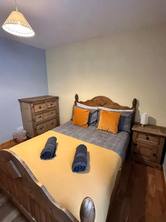 a bedroom with a large bed with blue slippers on it at Metro 8 Inverness City Centre in Inverness