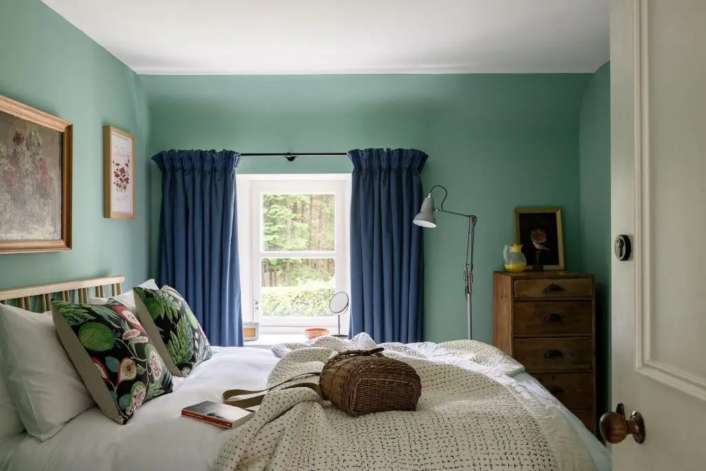 a bedroom with a bed with blue walls and a window at Exclusive use - The Coach House in Banchory