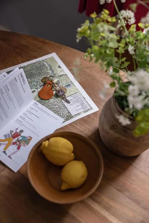 a wooden table with a plate of lemons and a newspaper at Exclusive use - The Coach House in Banchory