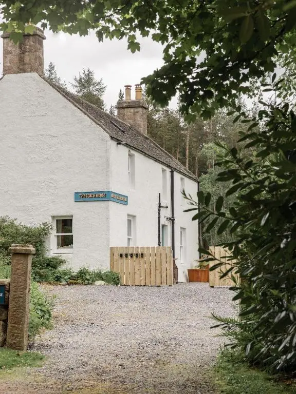 a white building with a blue sign on it at Exclusive use - The Coach House in Banchory