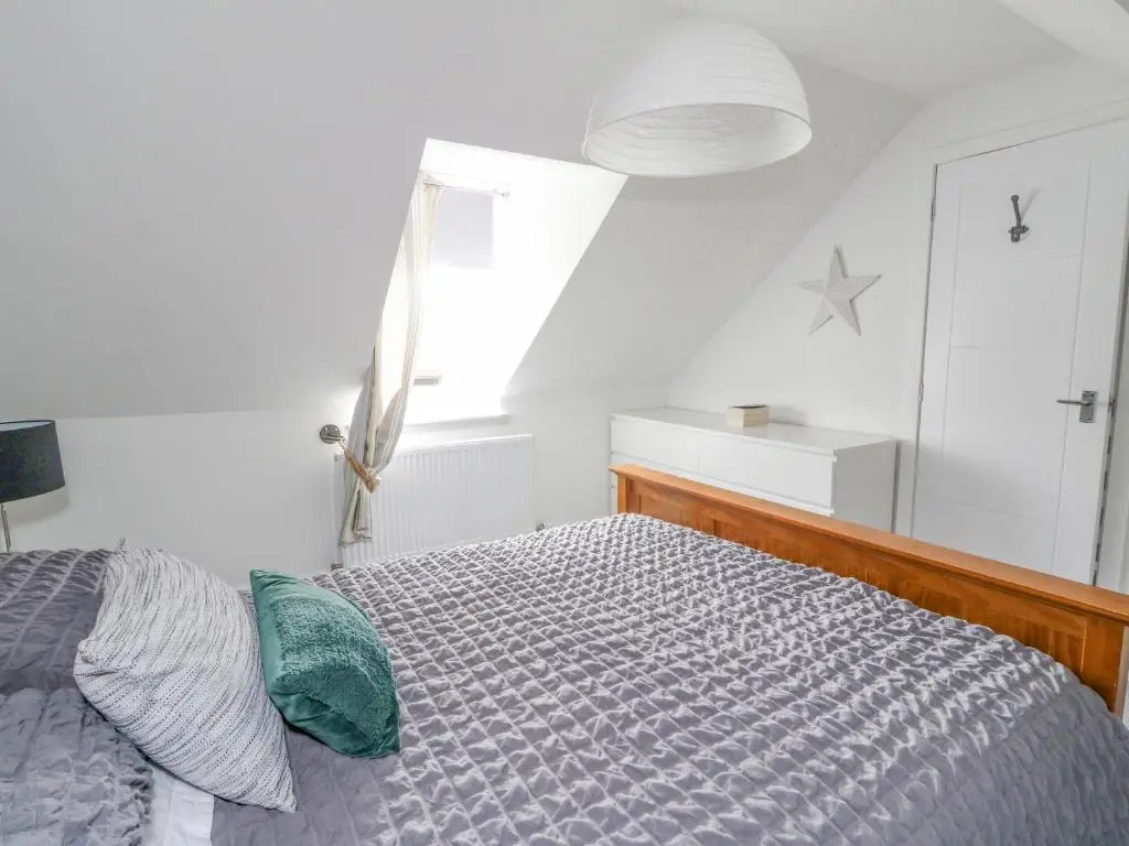 a bedroom with a bed and a window at Anchor Cottage in Elgin