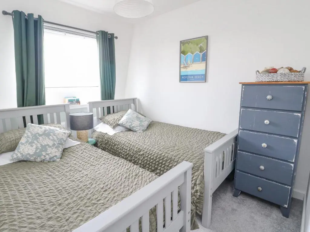 a bedroom with two twin beds and a dresser at Anchor Cottage in Elgin
