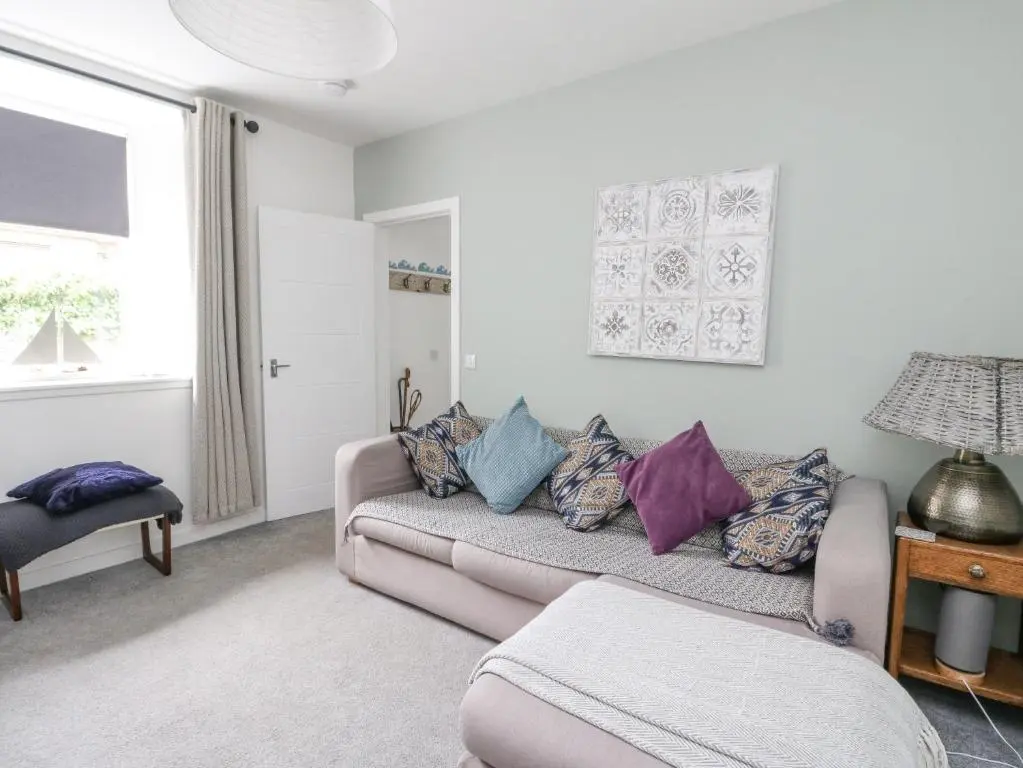 a living room with a couch with pillows on it at Anchor Cottage in Elgin
