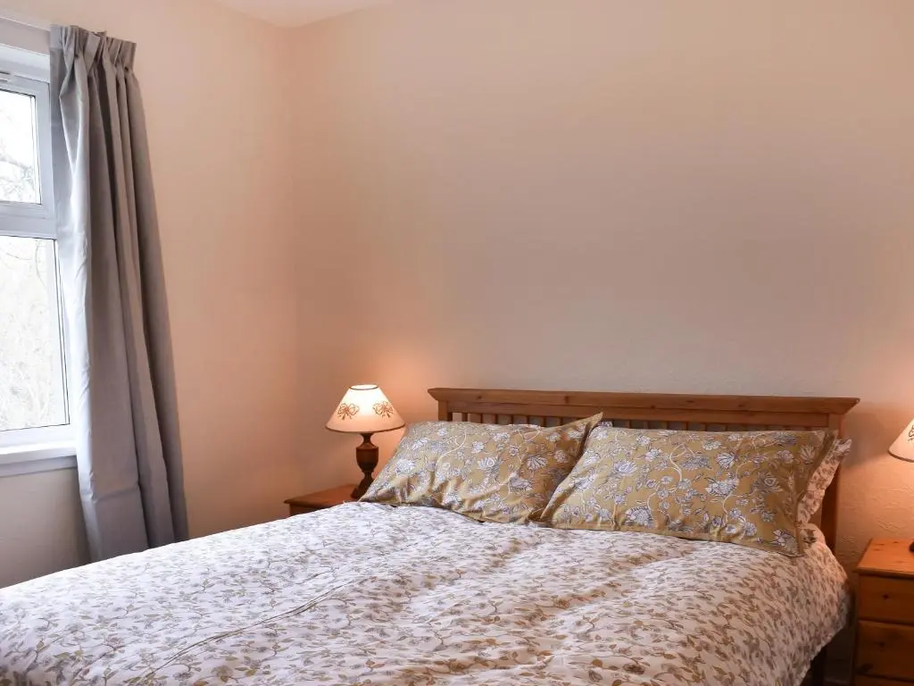 a bedroom with a bed and a window at Muir Cottage - Uk44788 in Bridge of Alford