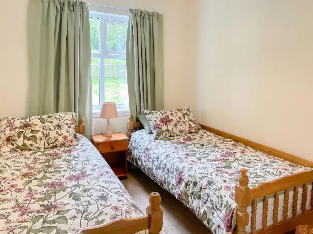 a bedroom with two beds and a window at Muir Cottage - Uk44788 in Bridge of Alford