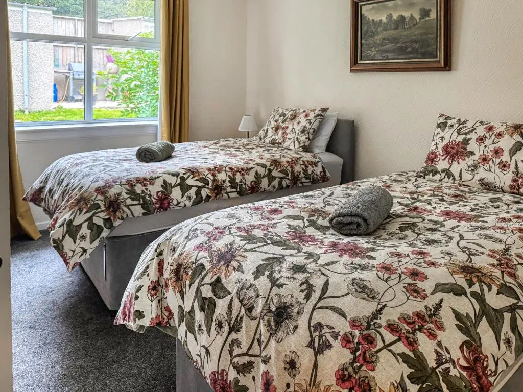 a bedroom with two beds and a window at Damil Cottage - Uk44789 in Bridge of Alford