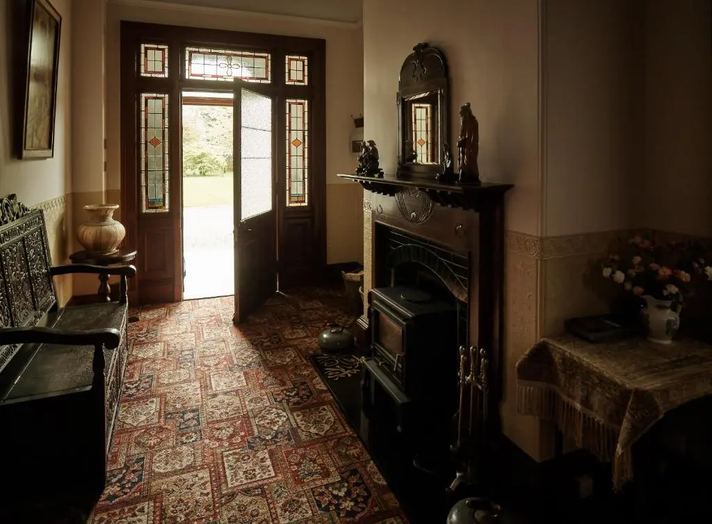 a living room with a fireplace and a door to a yard at Tali Ayer in Nairn