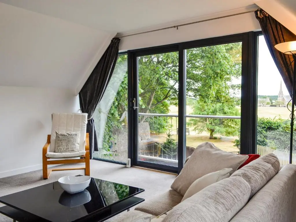 a living room with a couch and a table at Cedar Cottage in Aboyne