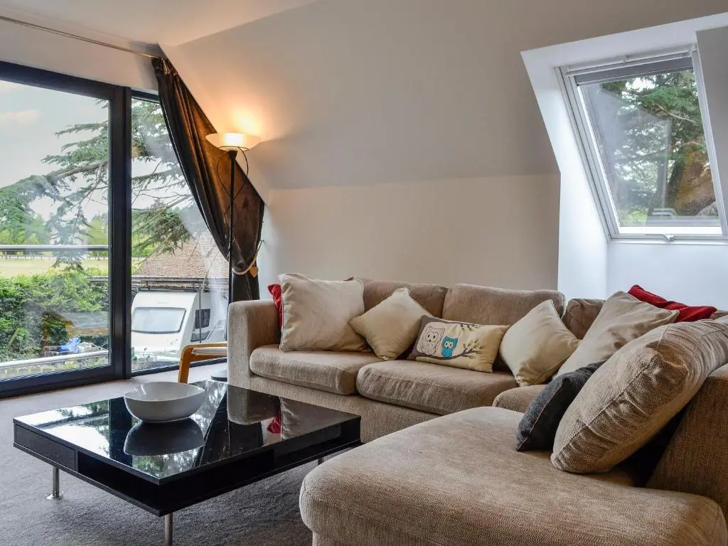a living room with a couch and a table at Cedar Cottage in Aboyne