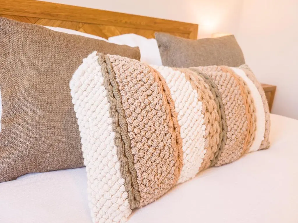a row of pillows sitting on a bed at 4 Ben Avon in Aviemore