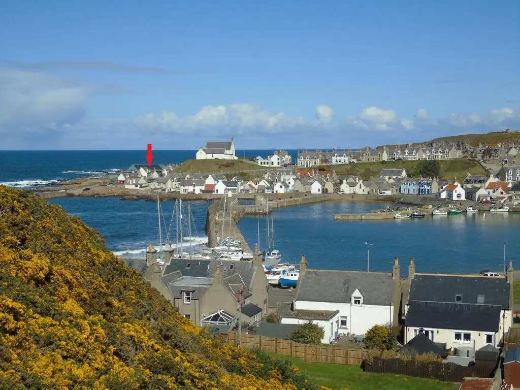 a small town with a harbor with boats in the water at Seafront holiday home in Findochty in Findochty