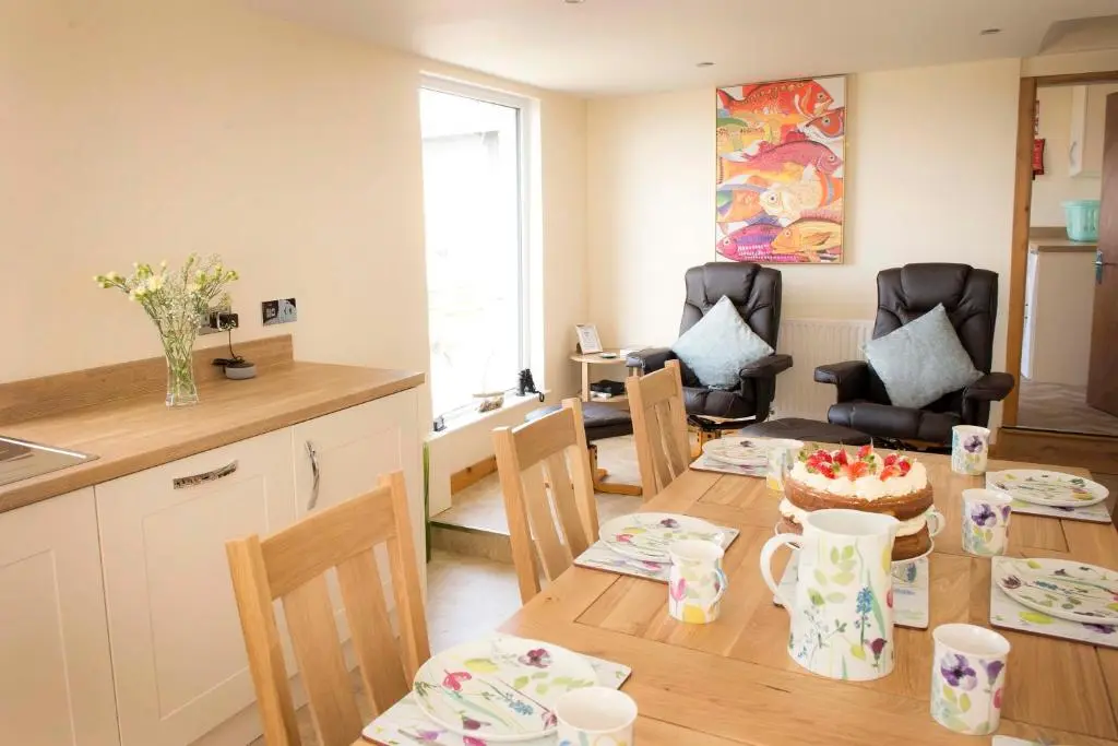 a kitchen and dining room with a table with a cake on it at Seafront holiday home in Findochty in Findochty