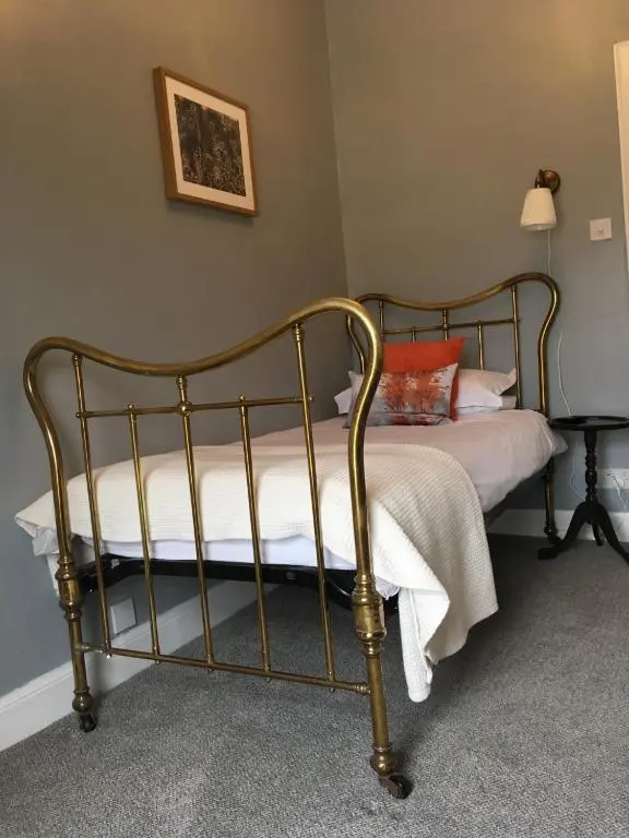 a bed with a metal frame in a room at Room Only Corbies Rest in Inverness