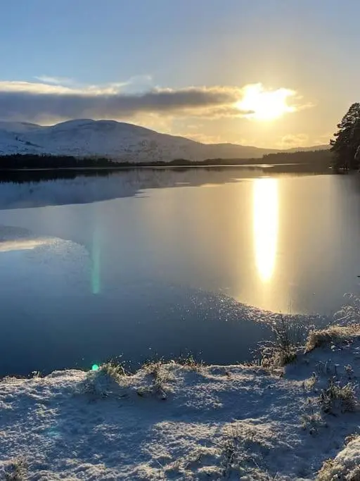 a view of a lake with the sun reflecting on the water at Perfect for country lovers in Grantown on Spey