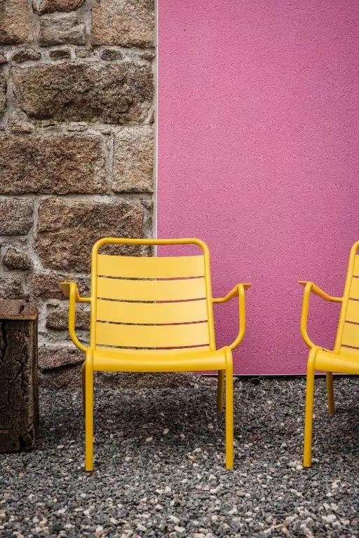 two yellow chairs sitting next to a wall at The Corner House in Banchory