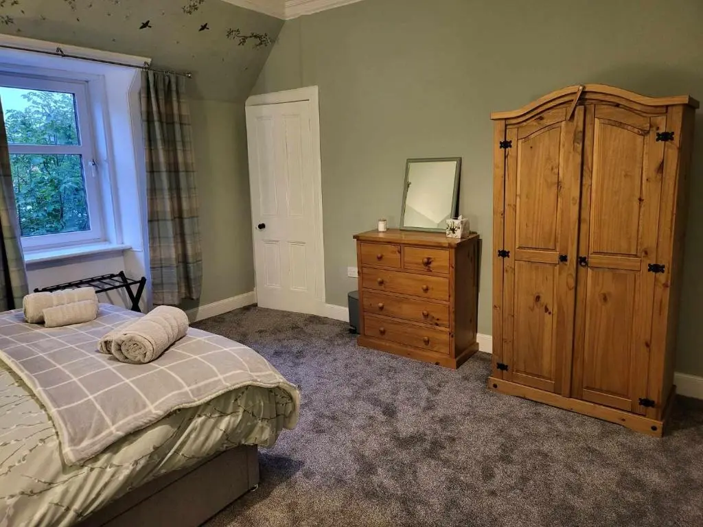 a bedroom with a bed and a dresser and a wooden cabinet at 16 Northcote Street, Wick in Wick