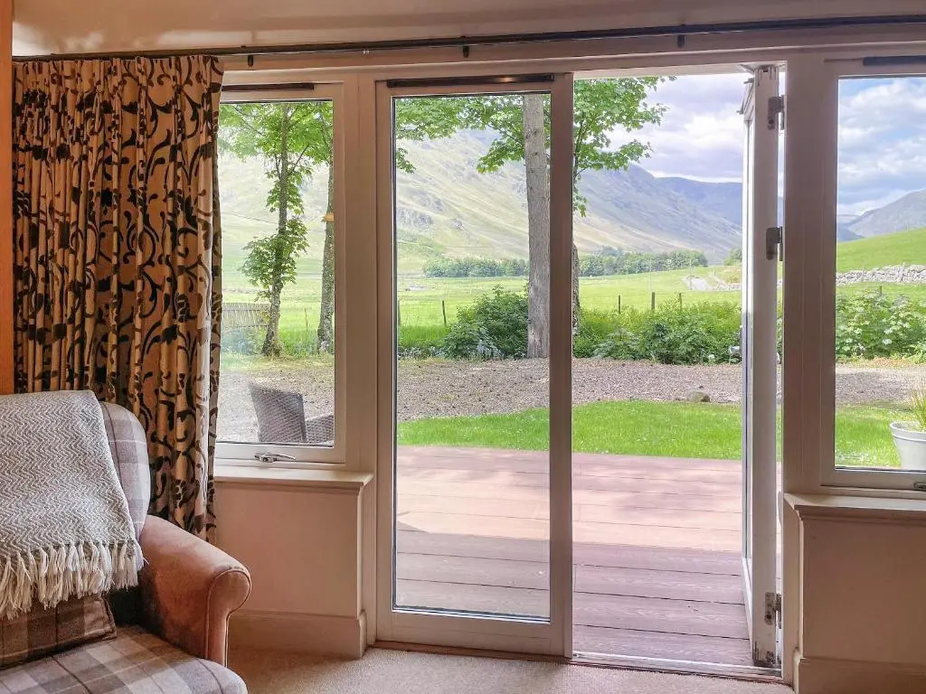 an open sliding glass door with a view of the mountains at Brandy Cottage - Ukc6855 in Millton of Clova