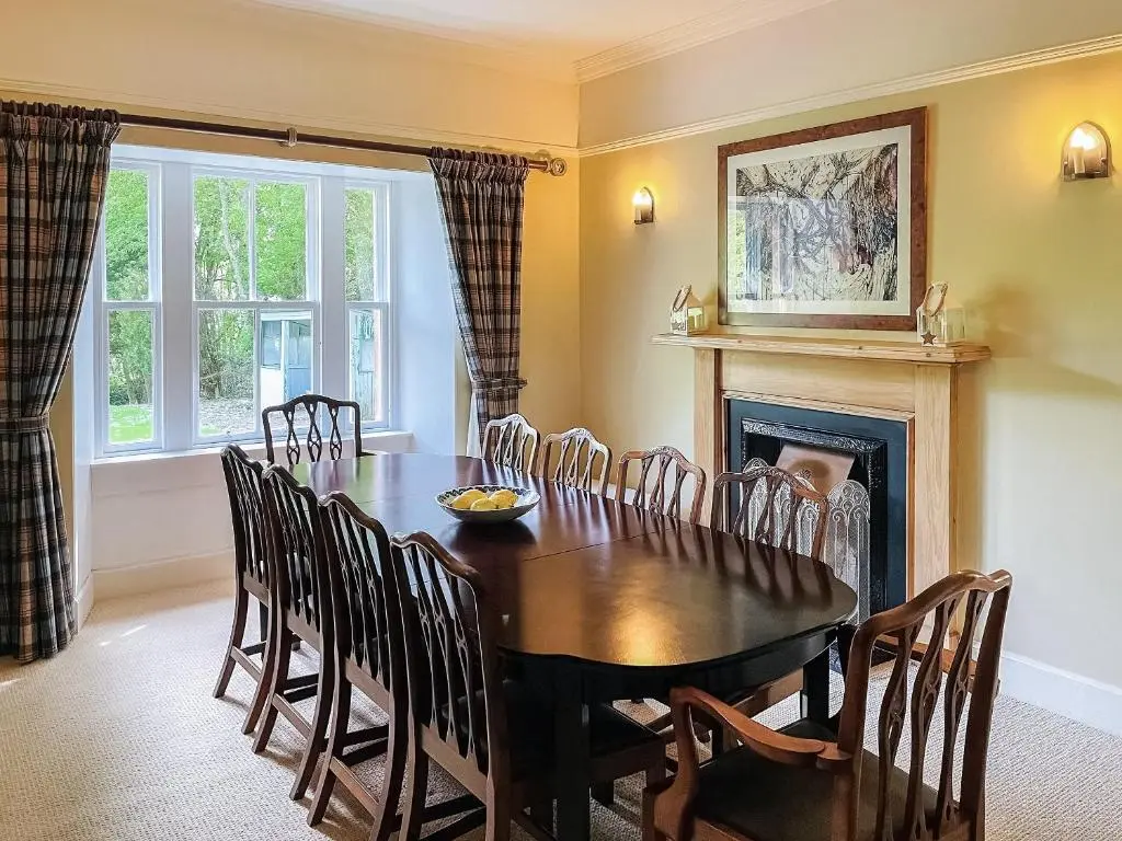 a dining room with a table and chairs and a fireplace at The Old Manse - Ukc6854 in Millton of Clova