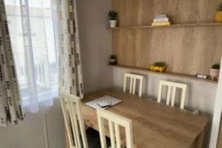 a wooden table and chairs in a kitchen with a window at Silver sands holiday park in Lossiemouth
