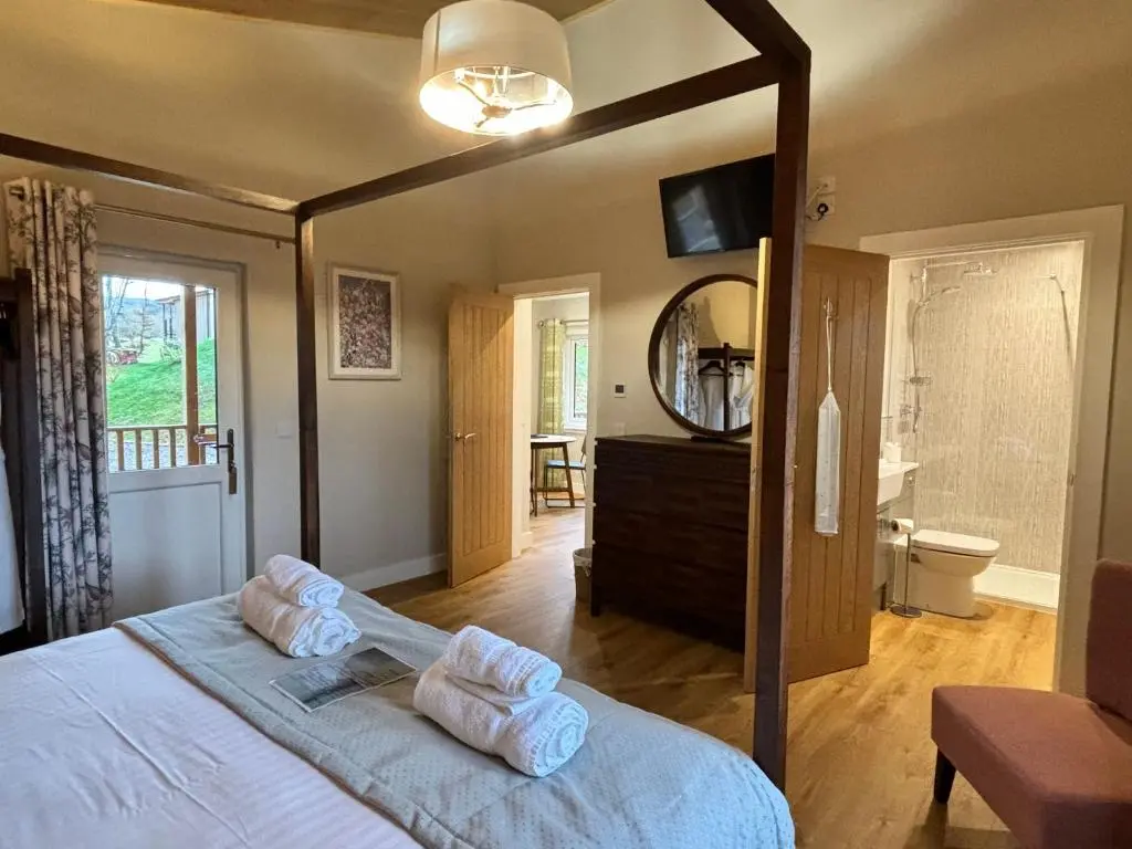 a bedroom with a bed with two towels on it at Breckland Lodge 2 with Hot Tub in Belladrum