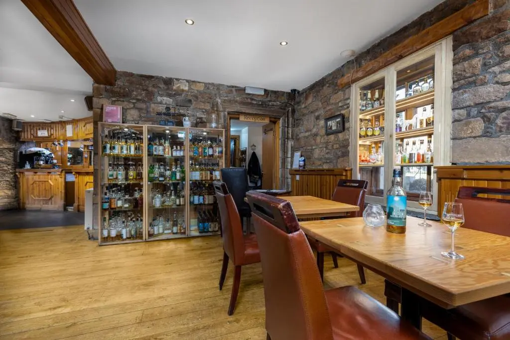 a dining room with a table and chairs at Dornoch Castle Hotel in Dornoch