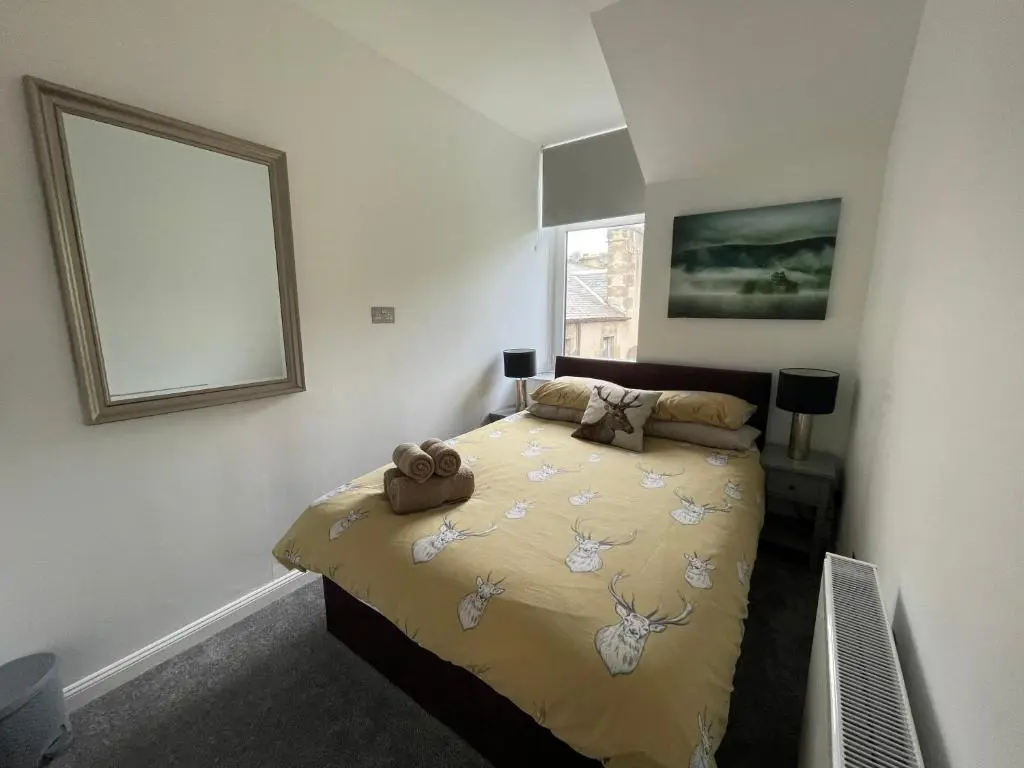 a bedroom with a bed with a teddy bear on it at Crown \u00e0ros beag, Ultra City Central 2 bedroom apartment with free parking onsite in Inverness