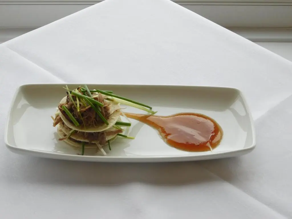 a plate of food with meat and vegetables on a table at Cullen Bay Hotel in Cullen