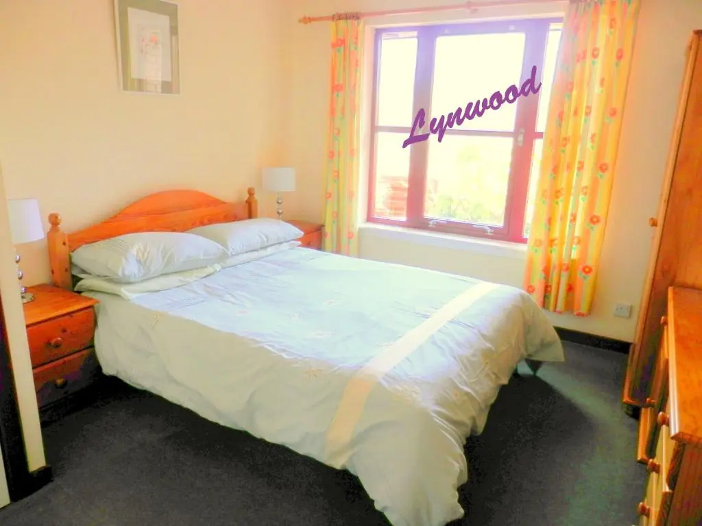 a bedroom with a large bed and a window at Cairngorm Highland Bungalows in Aviemore