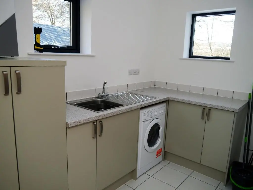 a kitchen with a sink and a washing machine at Laundry Cottage in Aberlour