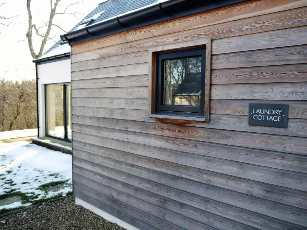 a building with a window and a sign on it at Laundry Cottage in Aberlour
