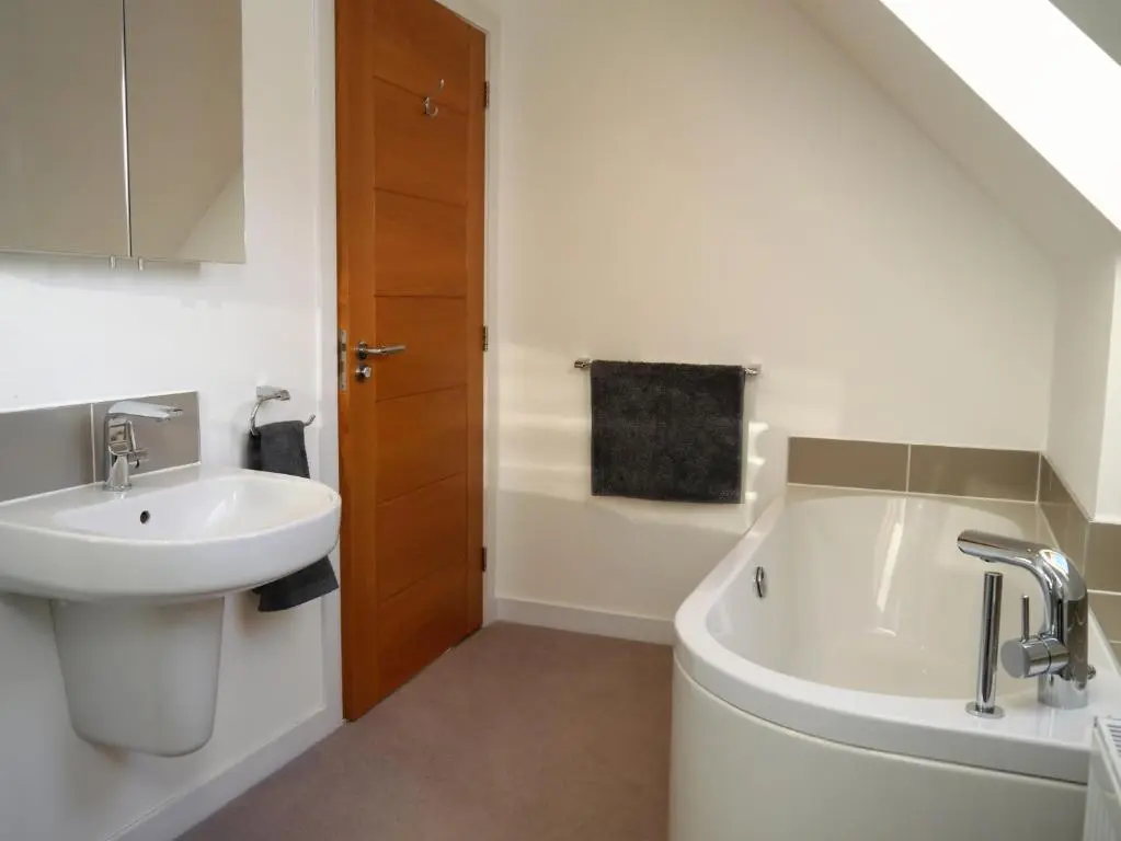 a bathroom with a sink and a bath tub at Laundry Cottage in Aberlour