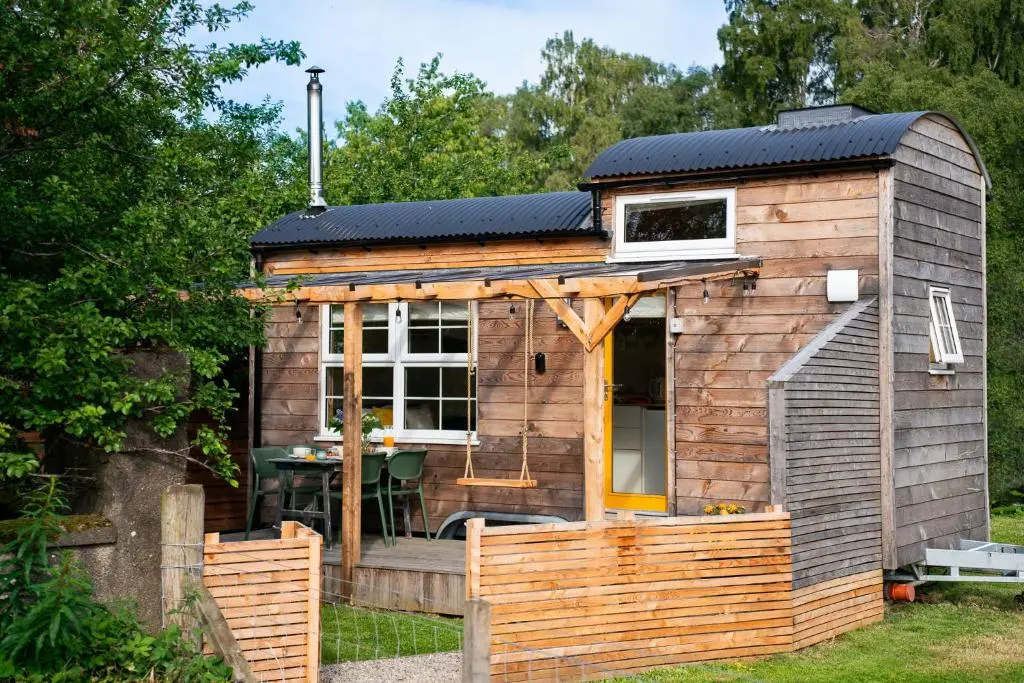a tiny house with a solar roof on it at Ailsa- Enchanting Tiny House with wood burner and hot tub in Cairngorms in Ballater