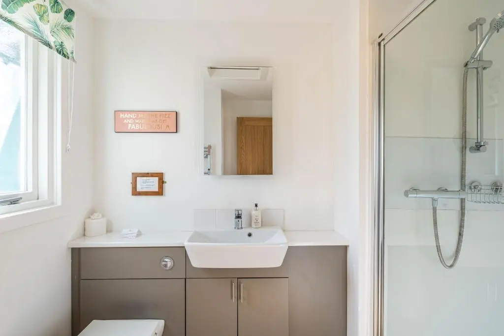 a bathroom with a sink and a shower at Bracken Lodge 15 with Hot Tub in Belladrum