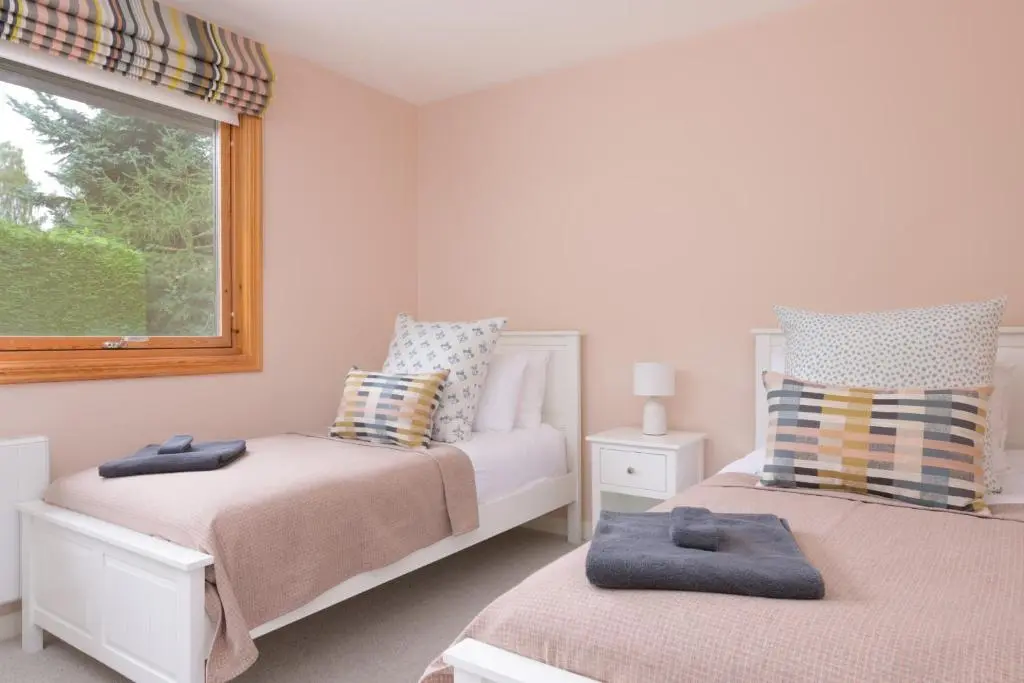 a bedroom with two beds and a window at Ballater Bungalow - 4 bed - Beautiful Garden in Ballater