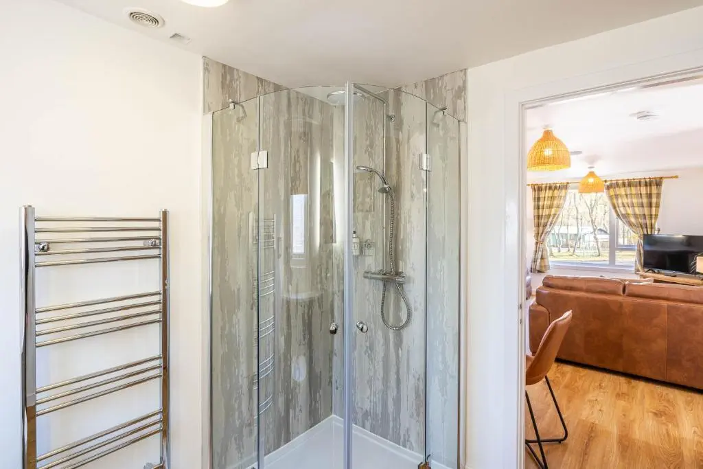 a shower with a glass door in a bathroom at Gorse Lodge 9 with Hot Tub in Belladrum