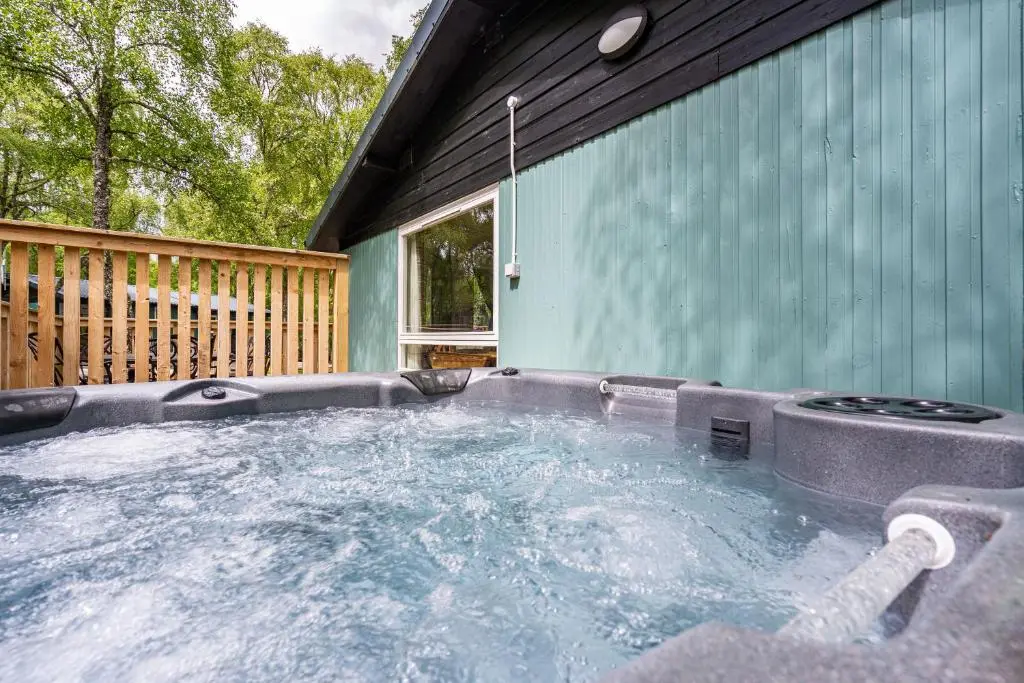 a hot tub in the backyard of a house at Heather Lodge 3 with Hot Tub in Belladrum