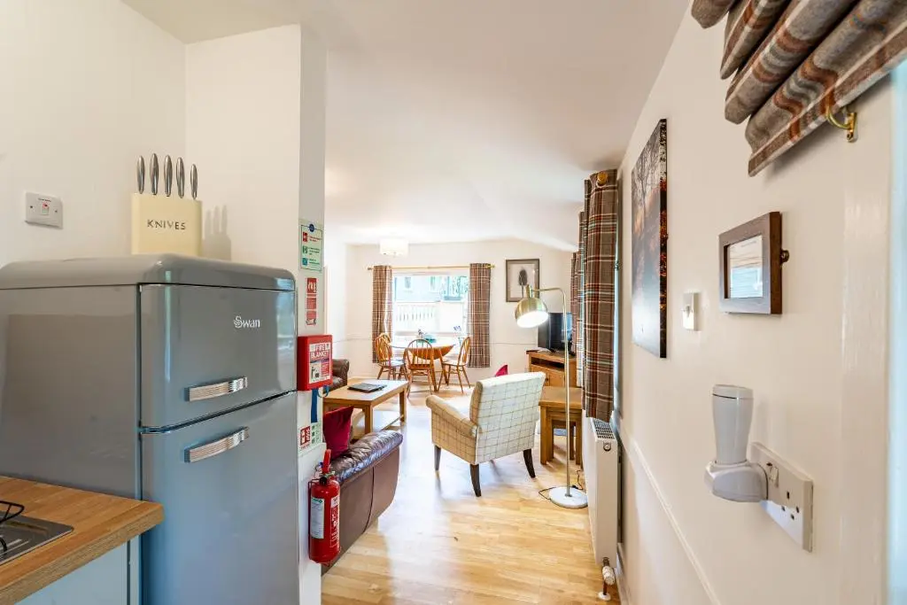 a kitchen and a living room with a refrigerator at Heather Lodge 3 with Hot Tub in Belladrum