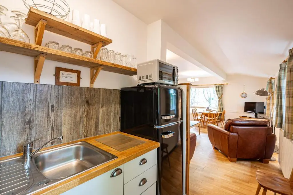 a kitchen with a sink and a refrigerator at Heather Lodge 10 with Hot Tub in Belladrum