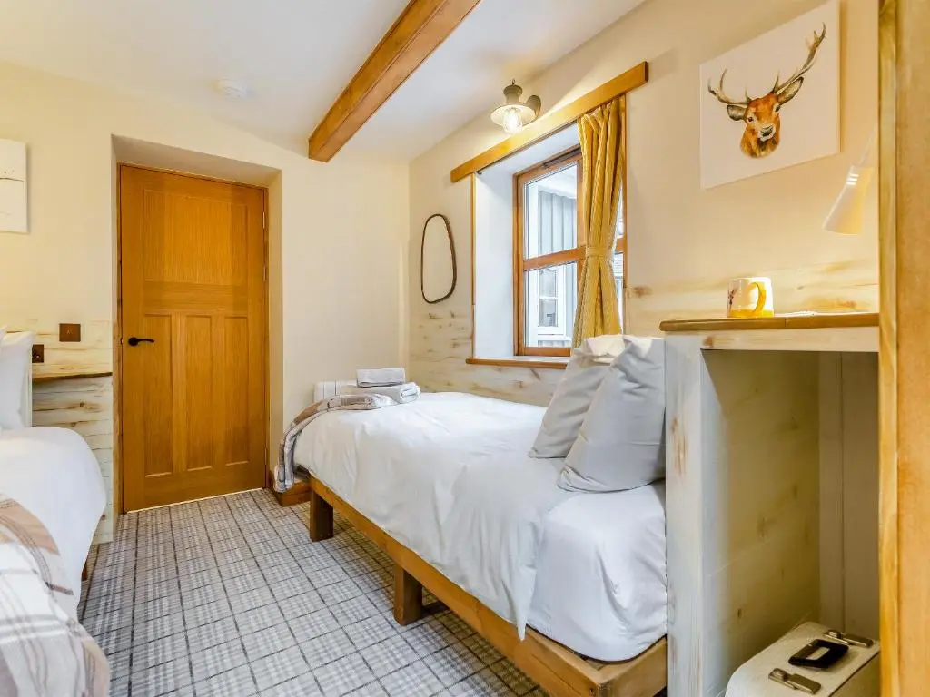 a bedroom with a bed and a window at Tigh-Na-Sgoile in Belladrum