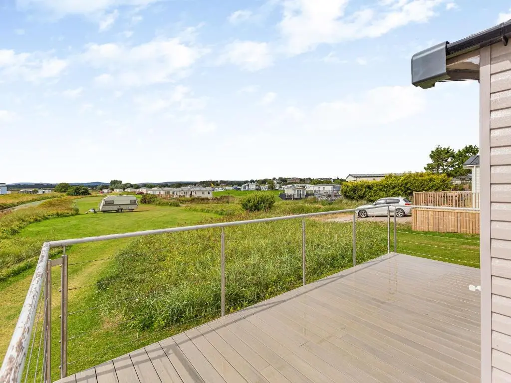 a deck with a view of a field at The Bordeux in Dornoch