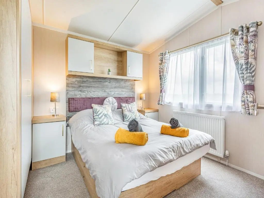 a bedroom with a large bed with yellow pillows at The Bordeux in Dornoch