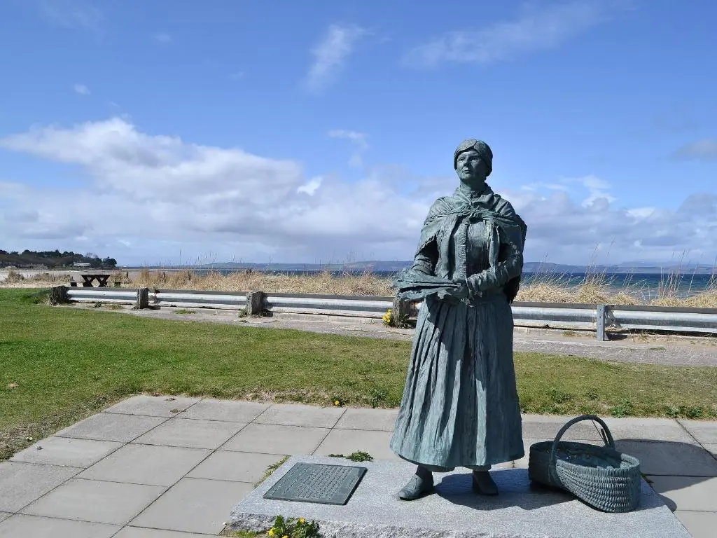 a statue of a woman standing on a sidewalk at Harbour Apartment in Nairn