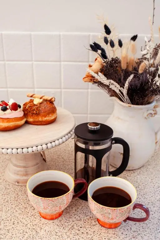 a counter with two cups of coffee and a plate of food at The River Nest in Dalneigh